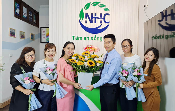 Ông Nguyễn Quang Hưng thay mặt Ban lãnh đạo Trung tâm tặng lẵng hoa chúc mừng các chị em